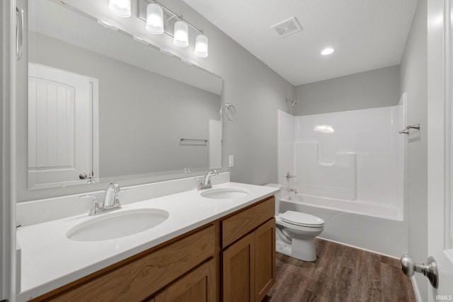 full bathroom with hardwood / wood-style flooring, vanity, toilet, and bathtub / shower combination