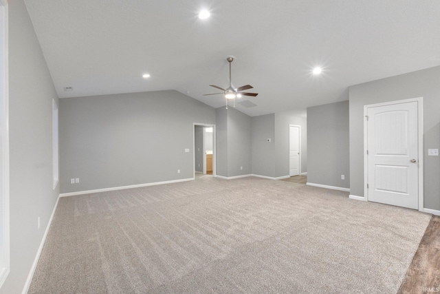 carpeted spare room featuring lofted ceiling and ceiling fan