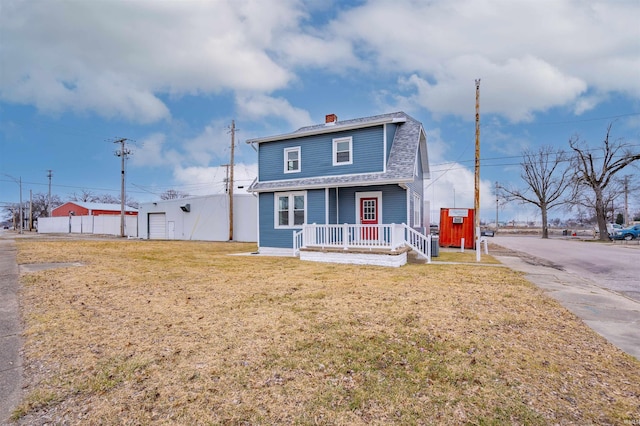 view of front facade with a garage, a front yard, and covered porch