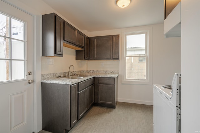 kitchen with white electric range, light stone countertops, sink, and dark brown cabinets