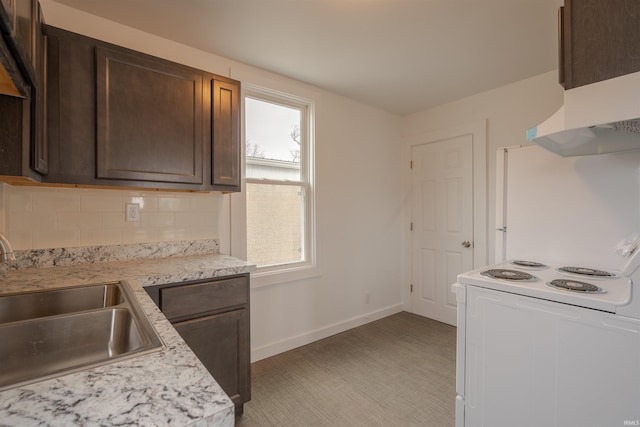 kitchen featuring sink, tasteful backsplash, dark brown cabinets, white appliances, and light stone countertops