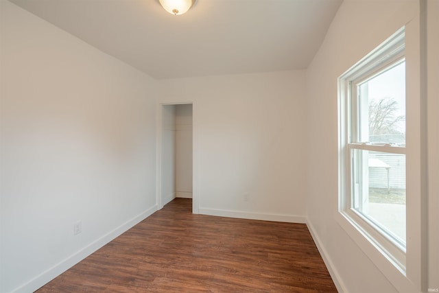 unfurnished room with dark wood-type flooring