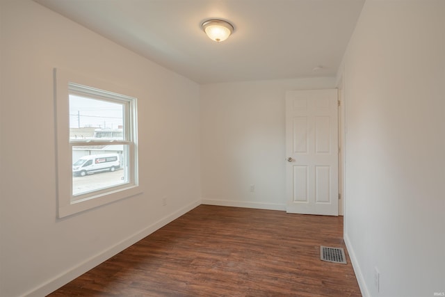 unfurnished room with dark hardwood / wood-style flooring