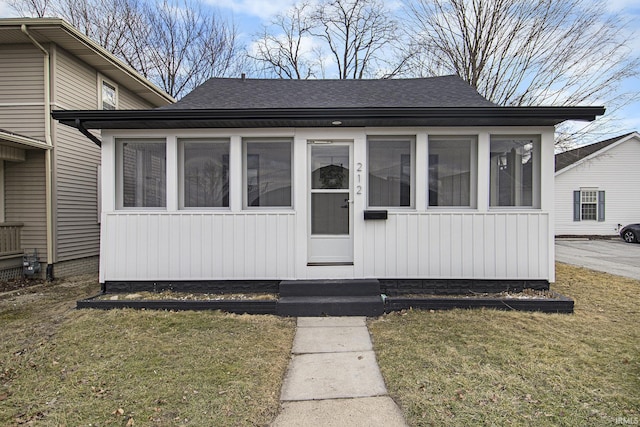 view of front facade featuring a front yard and a sunroom