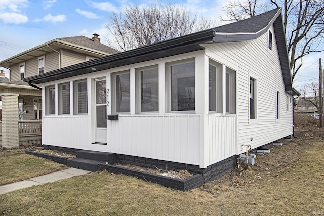 view of home's exterior featuring a yard and a sunroom