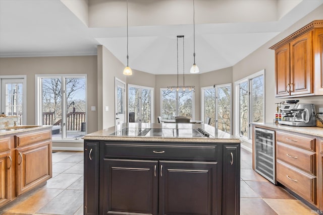 kitchen with black electric stovetop, beverage cooler, a center island, and hanging light fixtures