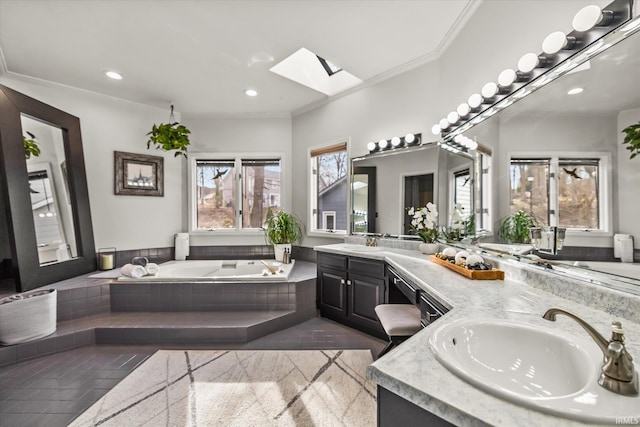 bathroom featuring a relaxing tiled tub, vanity, crown molding, and a skylight