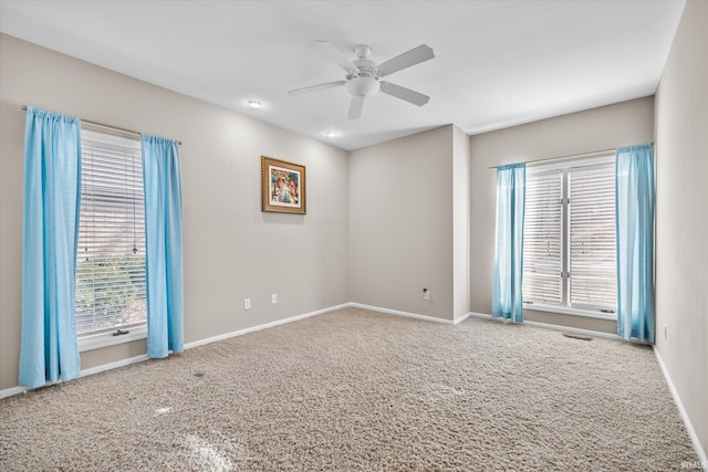 carpeted empty room with plenty of natural light and ceiling fan