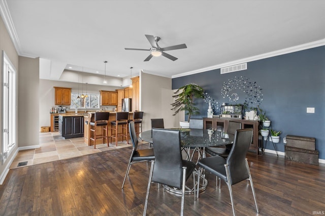 dining space featuring hardwood / wood-style flooring, ceiling fan, crown molding, and wine cooler