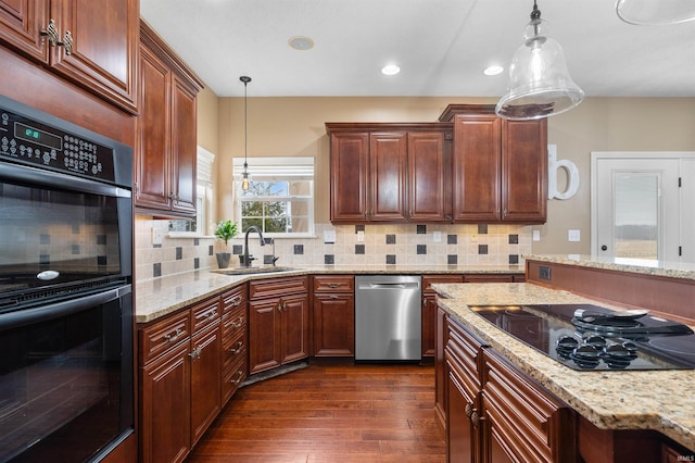 kitchen with pendant lighting, dark wood-type flooring, sink, and black appliances