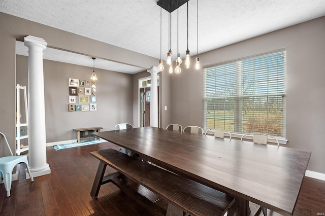 dining space with dark wood-type flooring and decorative columns