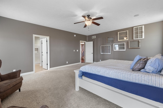 bedroom with carpet flooring, ceiling fan, and ensuite bath