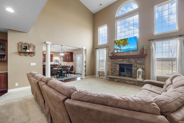 living room featuring ornate columns, plenty of natural light, light carpet, and a fireplace