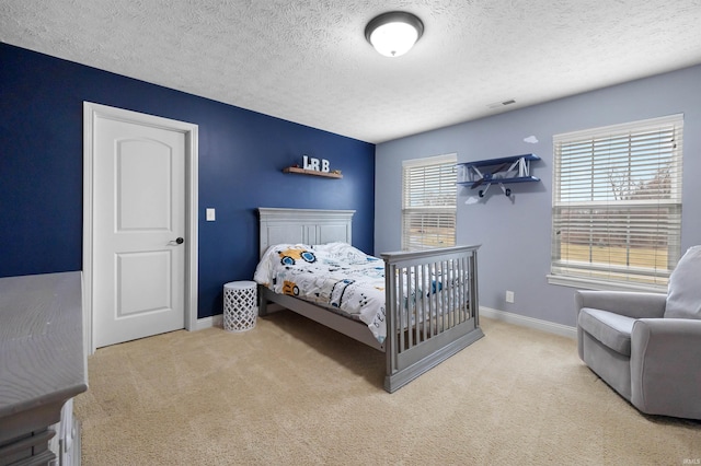 bedroom featuring light carpet and a textured ceiling