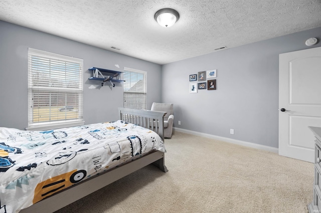 bedroom featuring light colored carpet and a textured ceiling