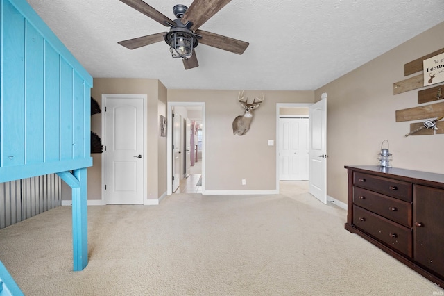 carpeted bedroom with ceiling fan, a textured ceiling, and ensuite bathroom