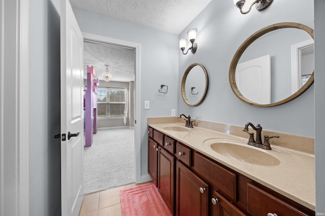 bathroom featuring vanity, tile patterned floors, and a textured ceiling