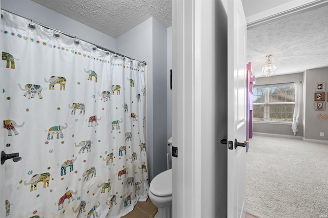 bathroom with curtained shower, toilet, and a textured ceiling