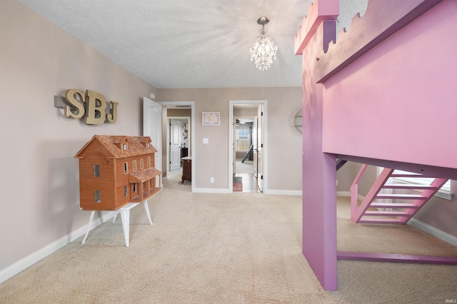 interior space featuring a chandelier, carpet, and a textured ceiling