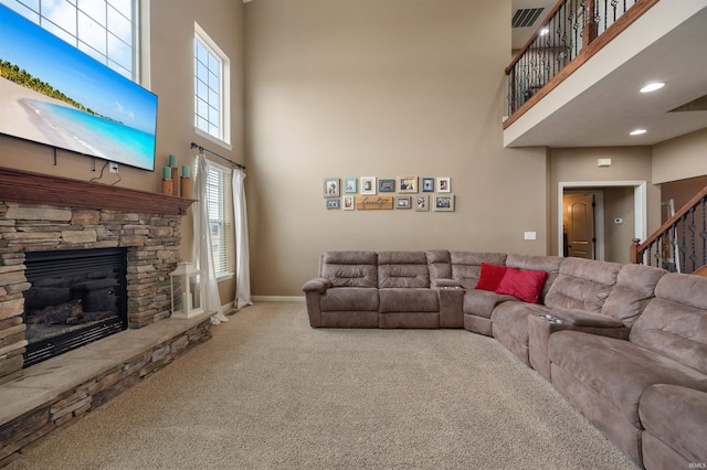 carpeted living room with a towering ceiling and a fireplace