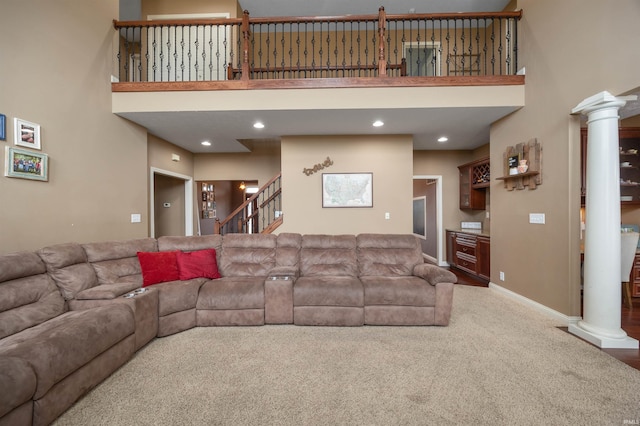 living room featuring ornate columns, carpet floors, and a towering ceiling