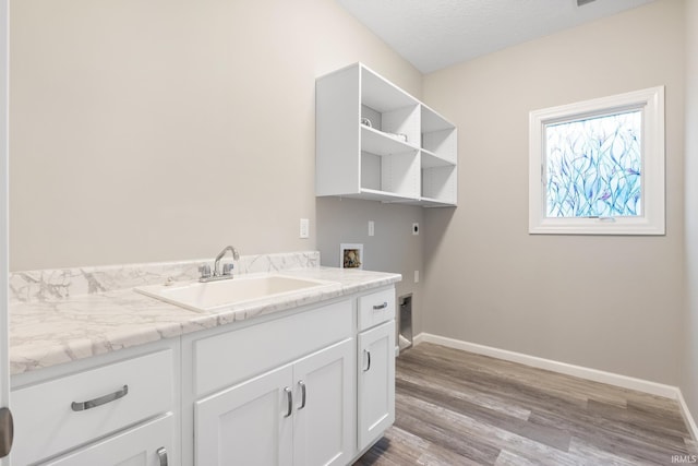 laundry room with sink, cabinets, washer hookup, light hardwood / wood-style floors, and electric dryer hookup