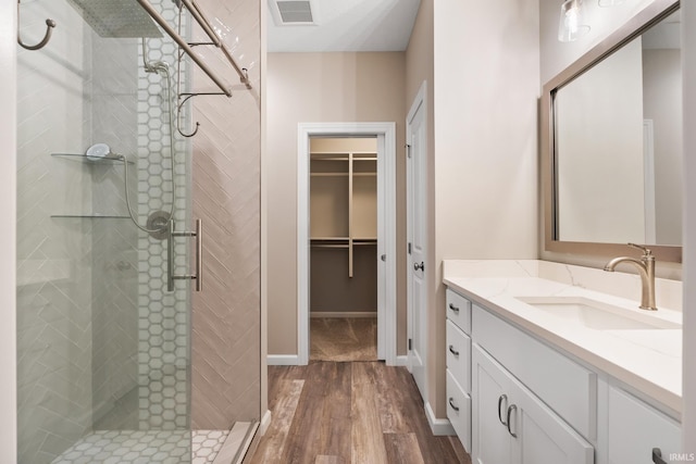 bathroom featuring vanity, a shower with door, and wood-type flooring