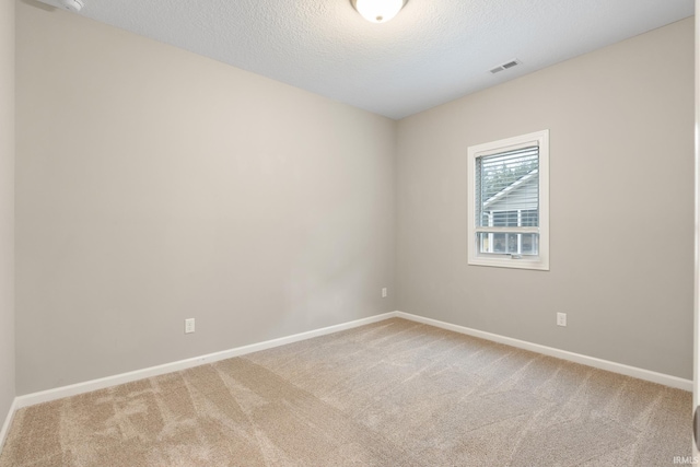 carpeted spare room featuring a textured ceiling