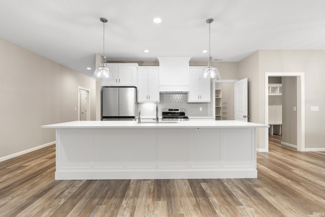 kitchen featuring white cabinetry, custom exhaust hood, stainless steel appliances, and a spacious island