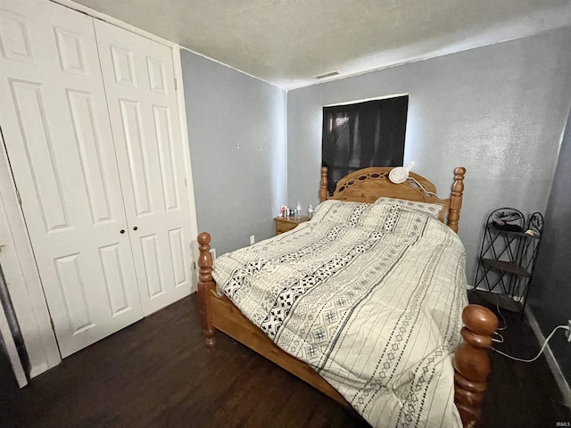 bedroom with dark hardwood / wood-style flooring and a closet