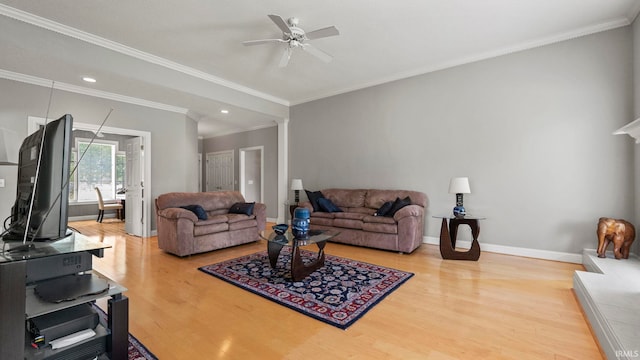 living room featuring crown molding, light hardwood / wood-style flooring, and ceiling fan