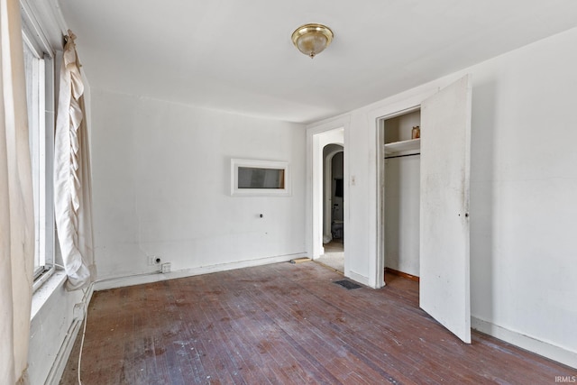 unfurnished bedroom featuring dark wood-type flooring and a closet