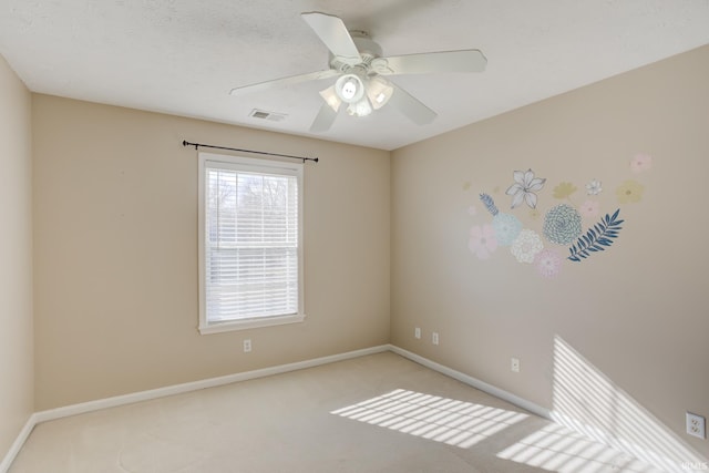 spare room featuring ceiling fan, light carpet, and a textured ceiling