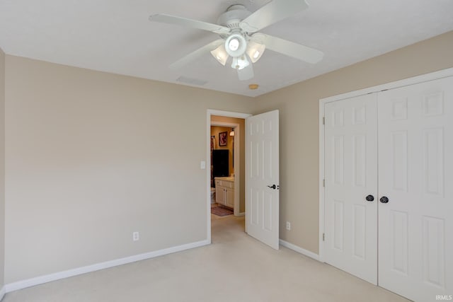 unfurnished bedroom featuring light colored carpet, a closet, and ceiling fan