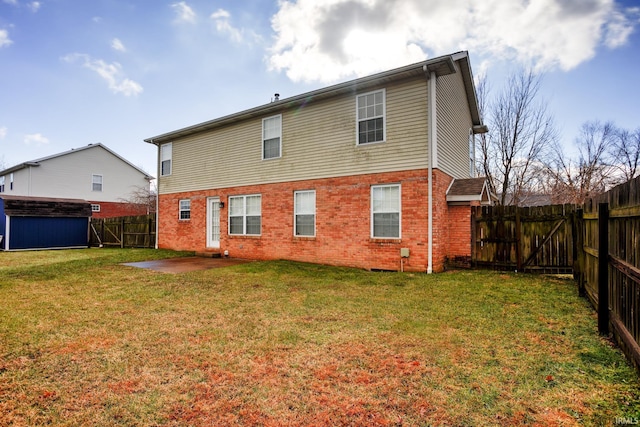 rear view of house with a storage shed, a lawn, and a patio area