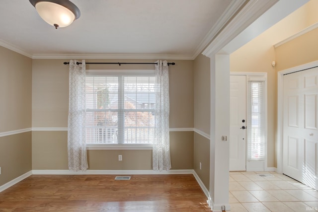 entryway featuring crown molding, light hardwood / wood-style flooring, and a wealth of natural light