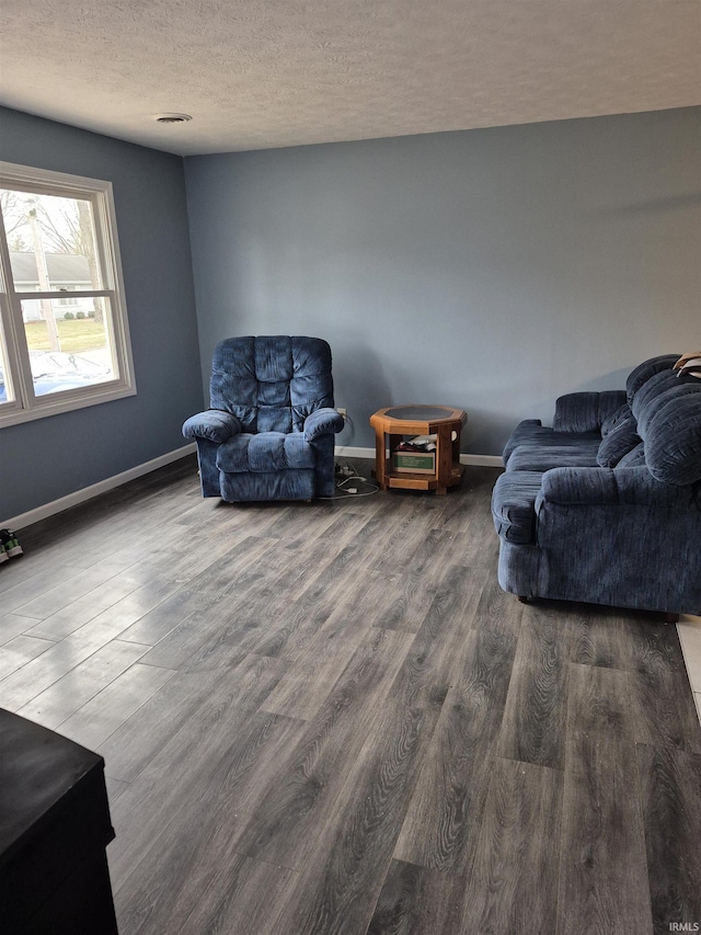 living room with dark hardwood / wood-style flooring and a textured ceiling