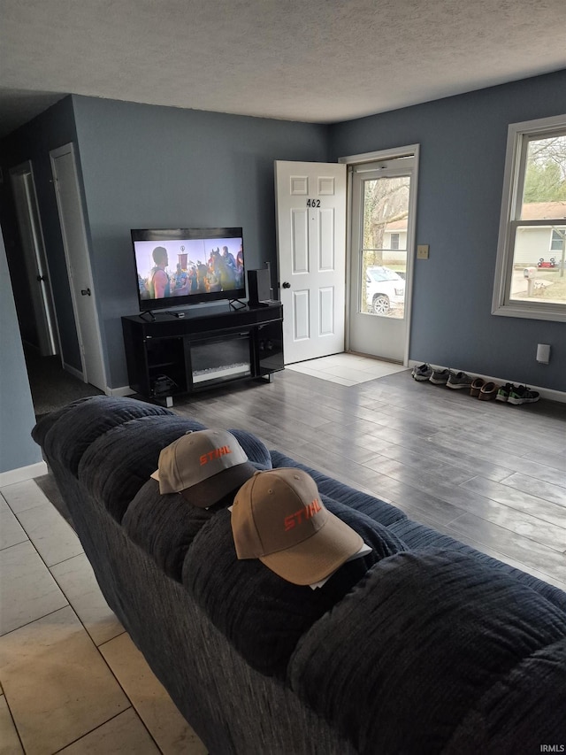 living room with a textured ceiling and light wood-type flooring