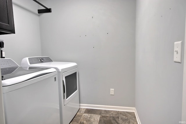 laundry area featuring separate washer and dryer and cabinets