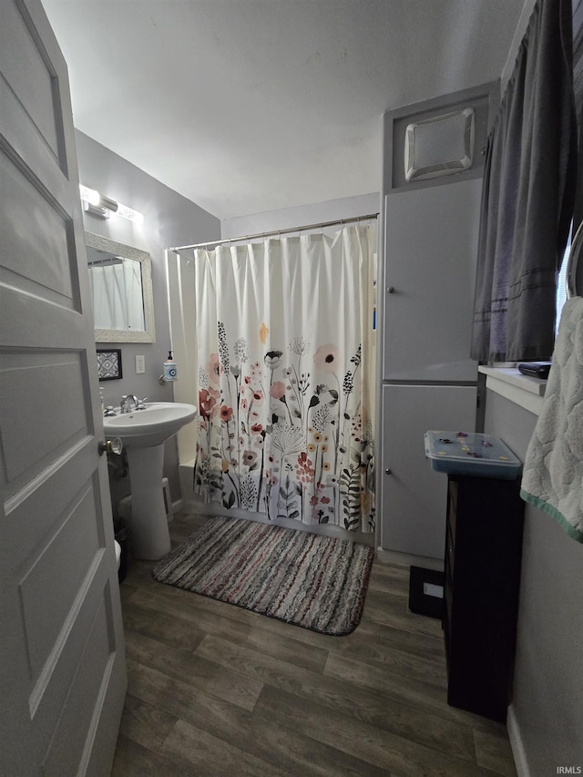 full bath with a shower with curtain and wood finished floors