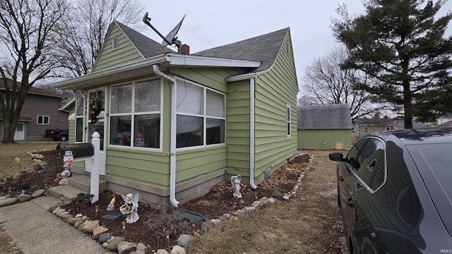 view of property exterior with a chimney and a shingled roof
