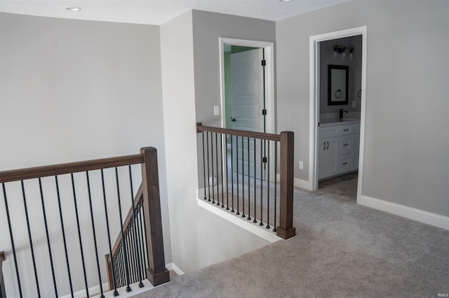 hall with sink and carpet flooring