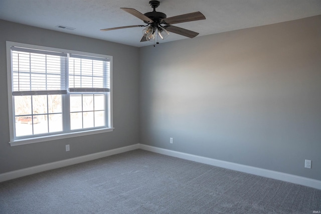 unfurnished room with ceiling fan and carpet