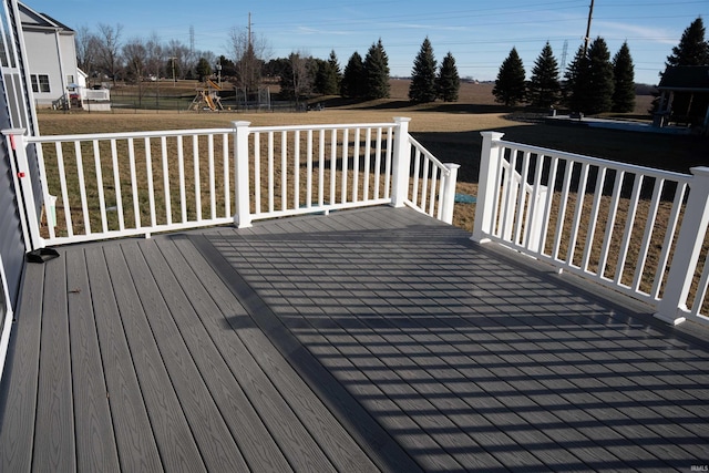 wooden deck with a yard and a playground