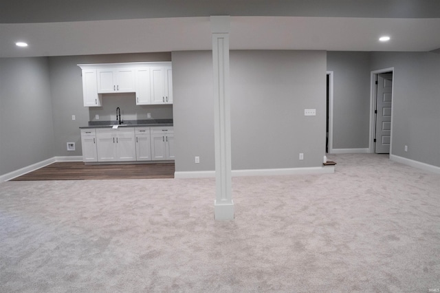 basement with light colored carpet and sink