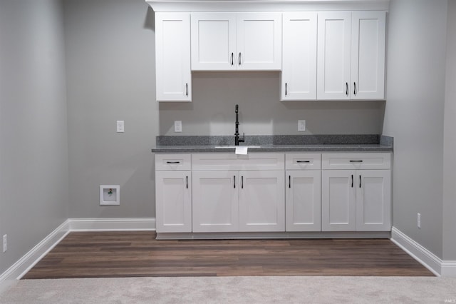 kitchen featuring sink, wood-type flooring, and white cabinets