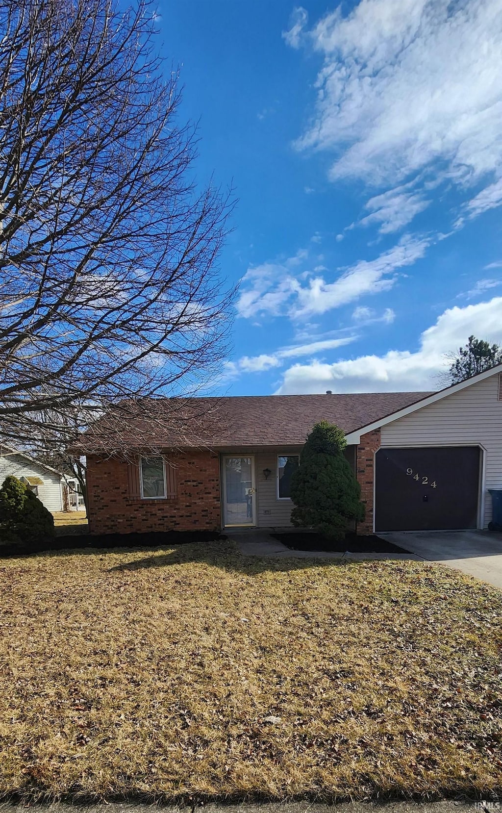 single story home featuring a garage and a front lawn