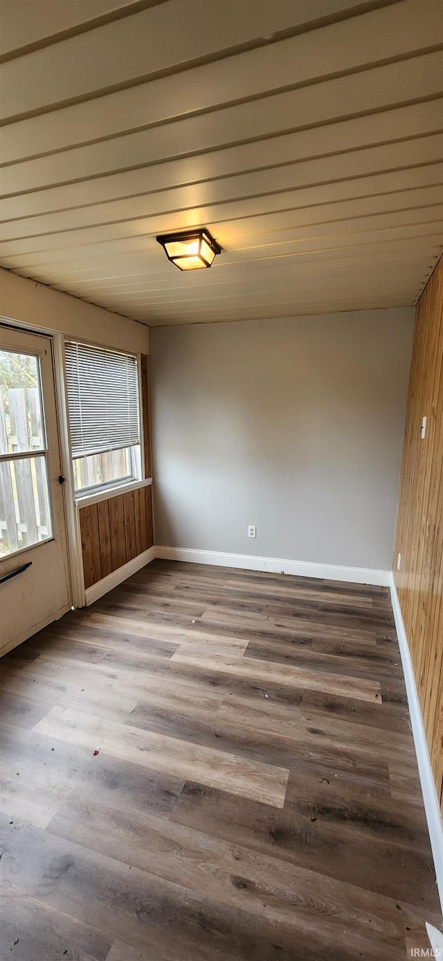 spare room featuring wooden walls, hardwood / wood-style floors, and wooden ceiling