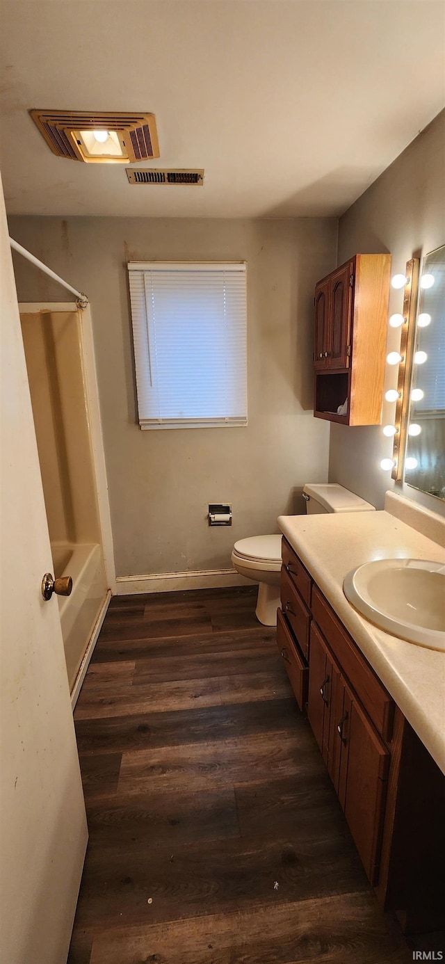 full bathroom with vanity, hardwood / wood-style floors, tub / shower combination, and toilet