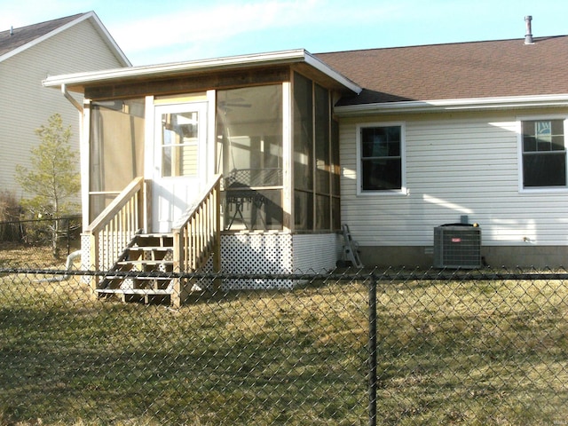 back of house featuring central AC unit, a yard, and a sunroom